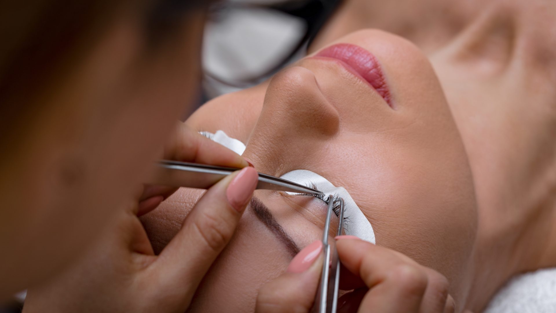 Une esthéticienne en train de réaliser une extension de cils sur une femme